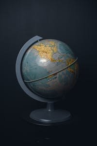 An antique world globe displayed on a dark black background, highlighting North America.