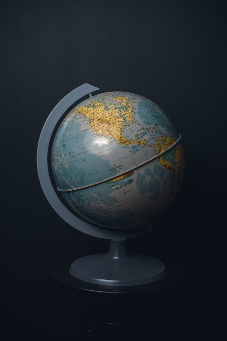 An antique world globe displayed on a dark black background, highlighting North America.